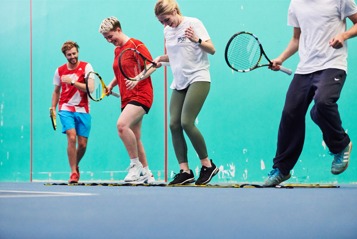 People on tennis court smiling