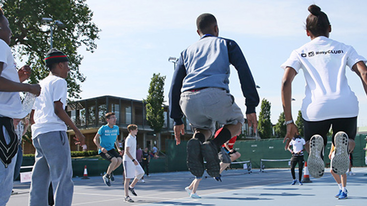Tennis court full with children playing together