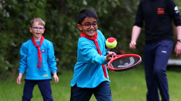 Two boys playing tennis with the Scouts