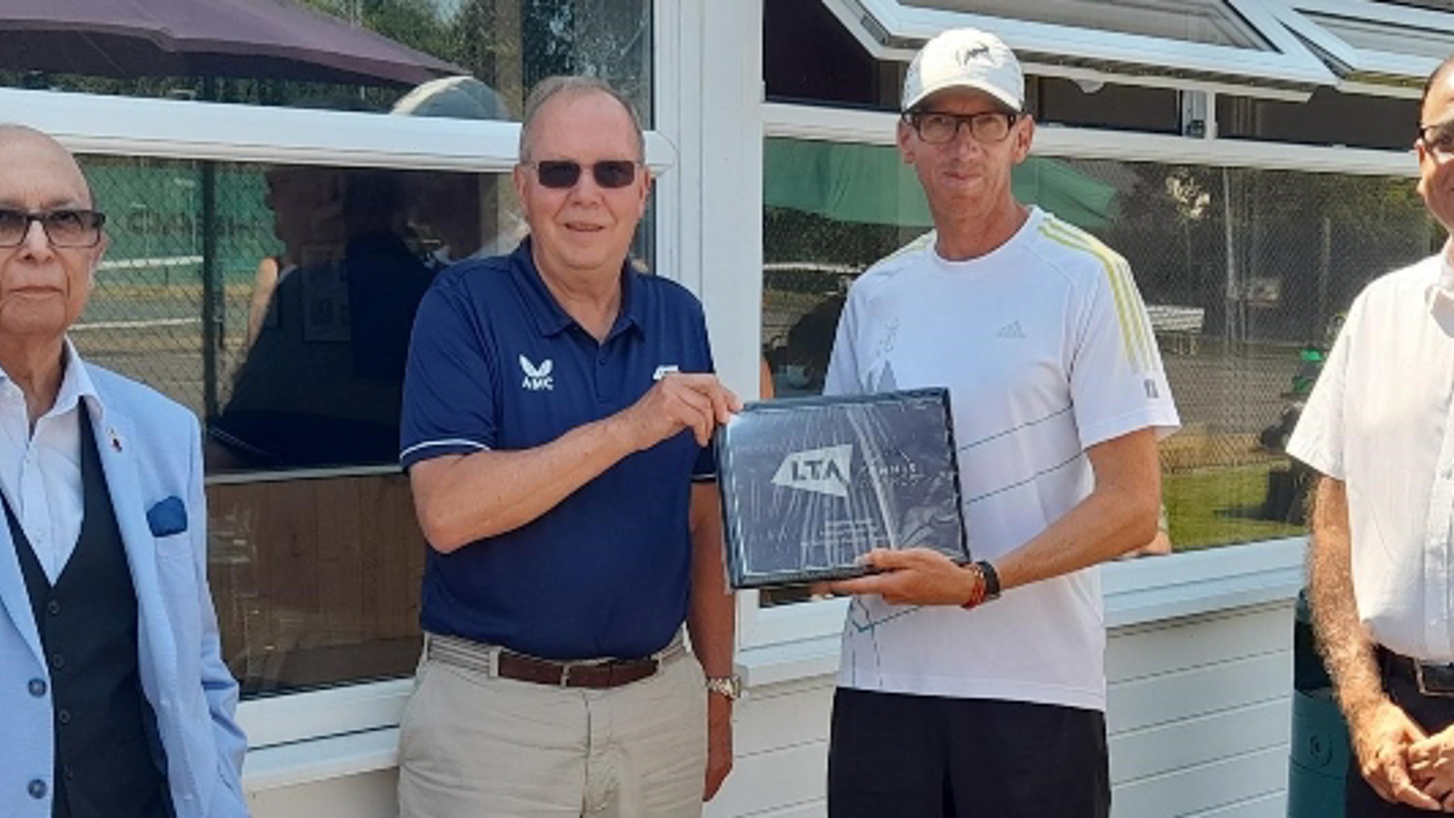 Group of men at Riverside Tennis Club with Mohammad Yasin and David Rawlinson holding the framed award