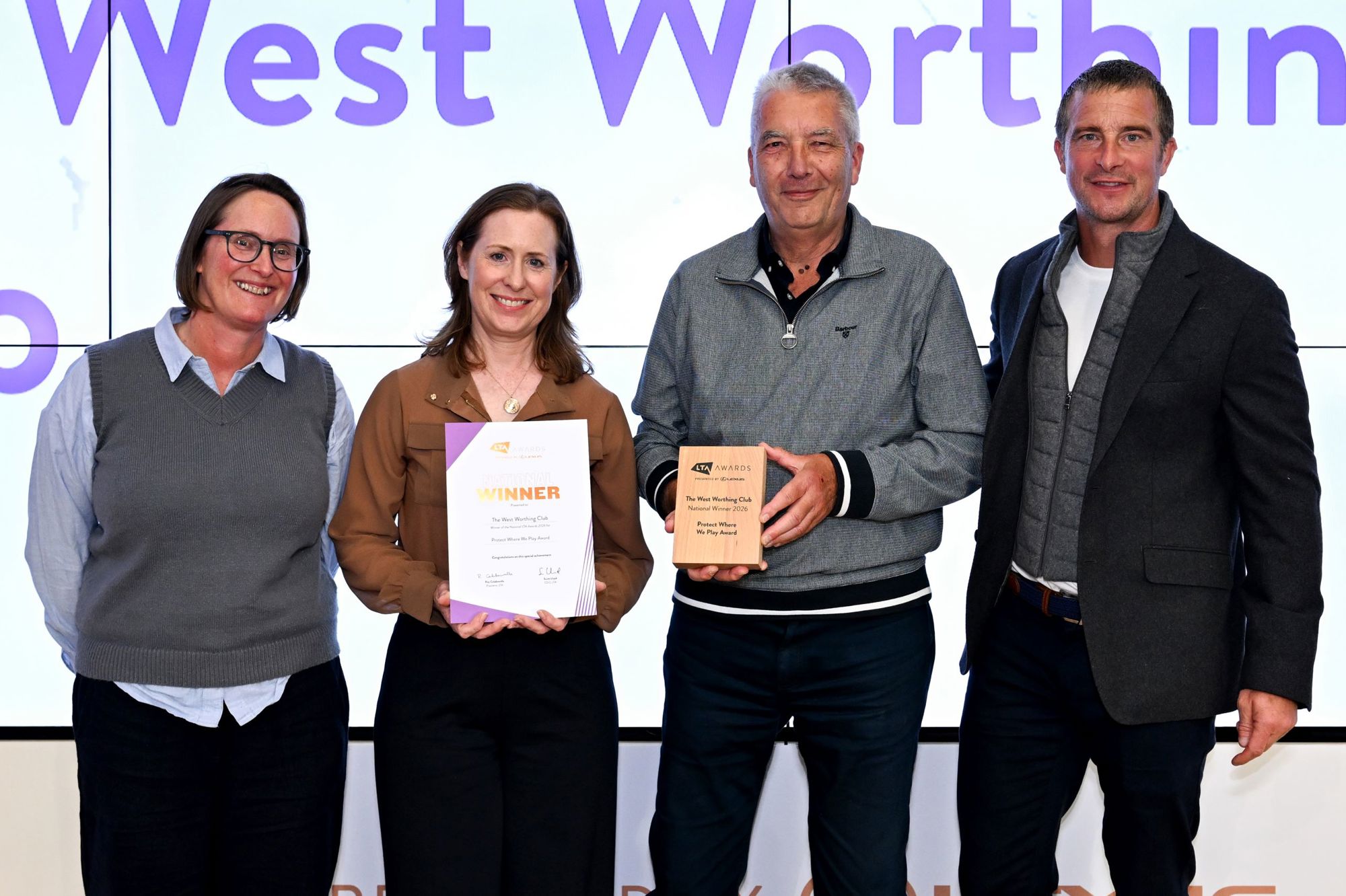 Bear Grylls posing with LTA Award winners on stage