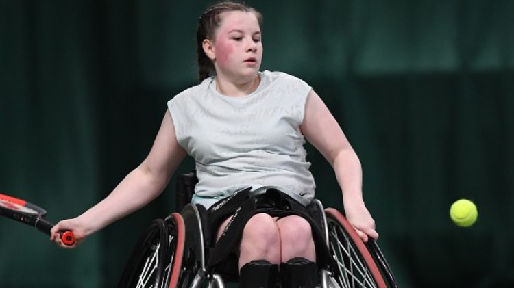 Girl playing tennis in wheelchair