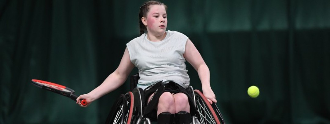 Girl playing tennis in wheelchair