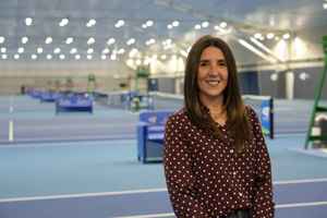 LTA colleague Jo Walsh standing in front of the indoor hard courts at the National Tennis Centre