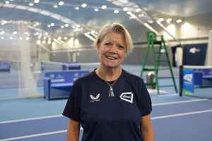 LTA colleague Julie Jones standing in front of the indoor hard courts at the National Tennis Centre