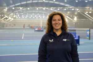 LTA colleague Marina Homsi standing in front of the indoor hard courts at the National Tennis Centre
