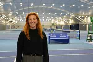 LTA colleague Rhona Hurley standing in front of the indoor hard courts at the National Tennis Centre