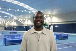 LTA colleague Richard Sackey-Addo standing in front of the indoor hard courts at the National Tennis Centre