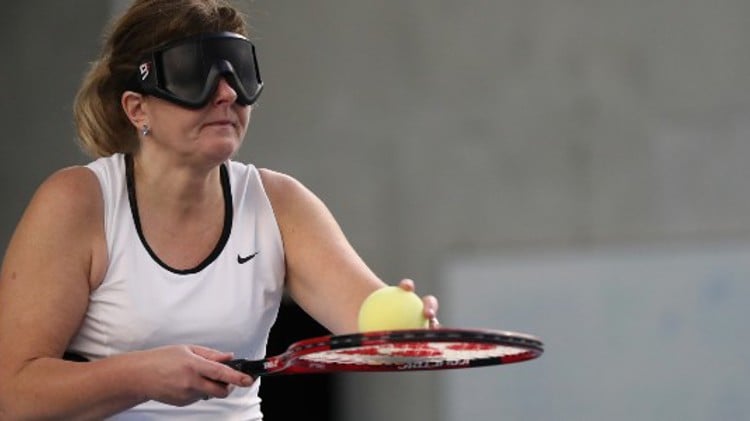 virtually impaired woman holding ball on racket