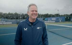 Tennis coach, Chris Wilkinson  smiling on court