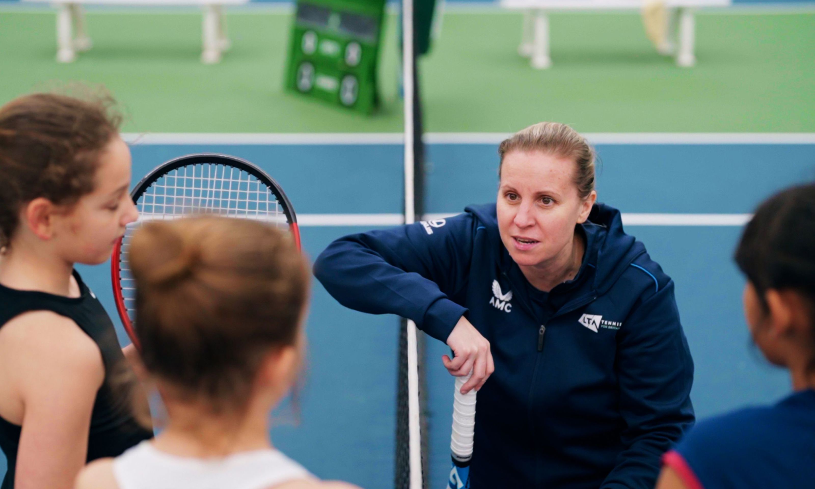 Coach Hollie Bainbridge chatting to young players by the net