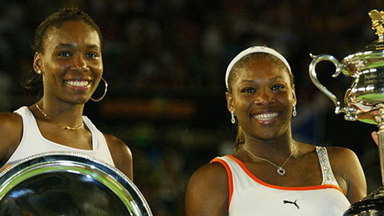 Serena and Venus Williams smiling with their trophies