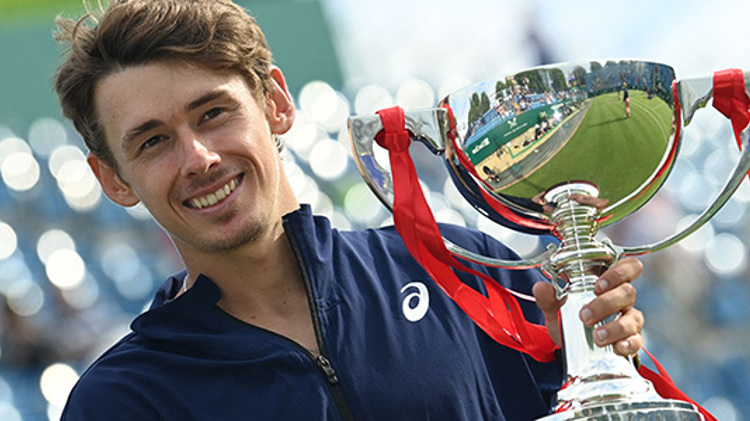 Alex de Minaur holding the champions trophy at Eastbourne