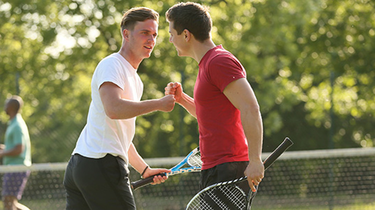 Two men fist pumping while playing tennis