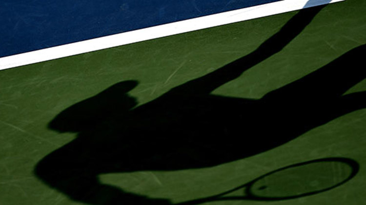 a shadow of a tennis player on a court