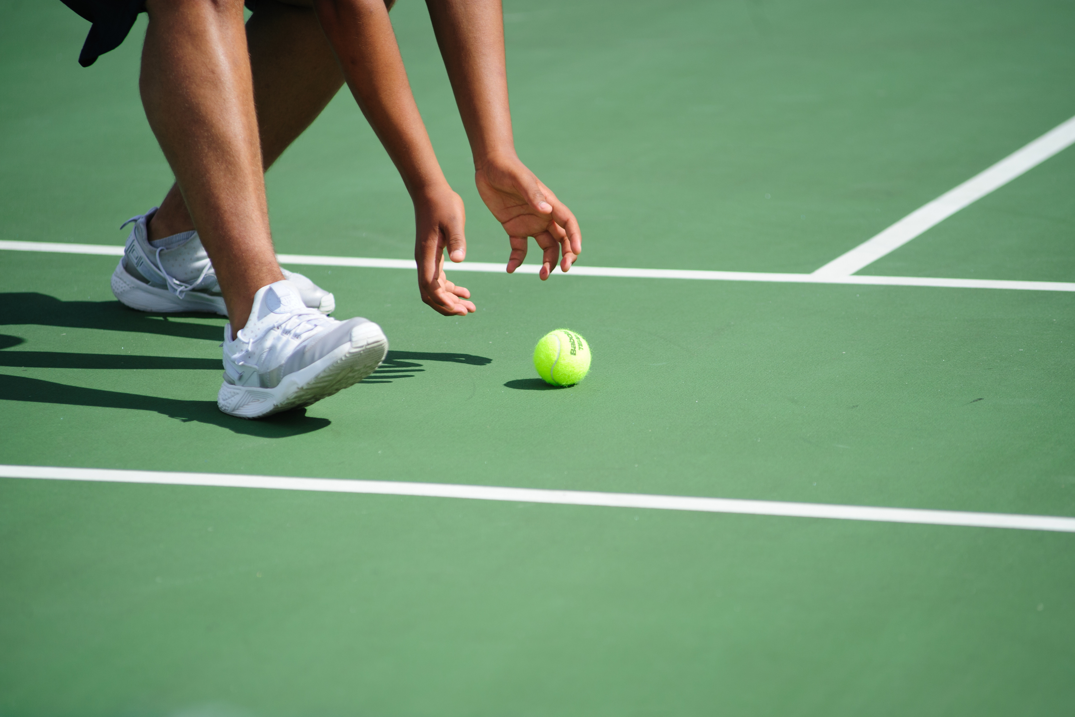 A ball girl chasing a tennis ball