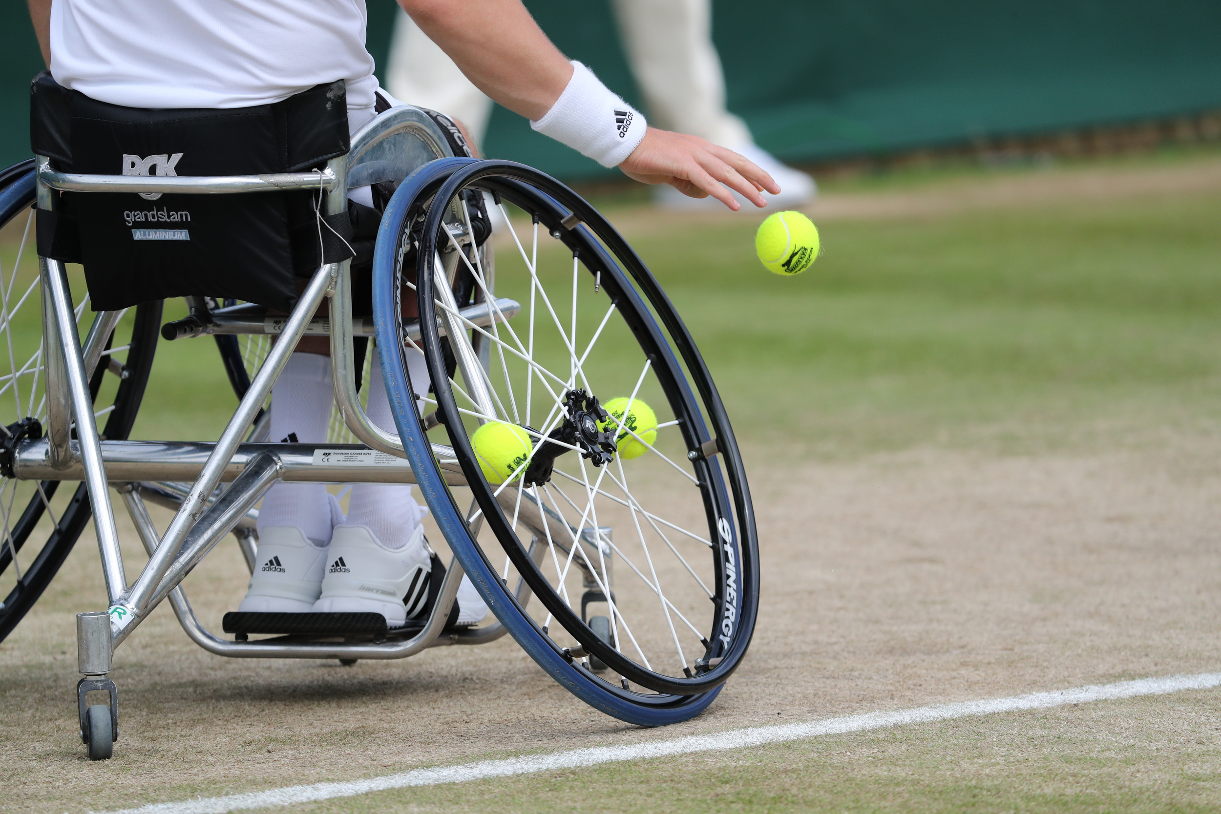 Wheelchair and tennis balls on grass