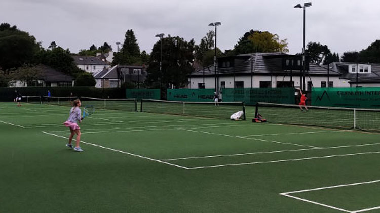 players playing a match on three of the grass courts at giffnock tennis club