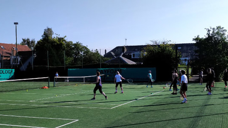 adult players training  on two courts at giffnock tennis club
