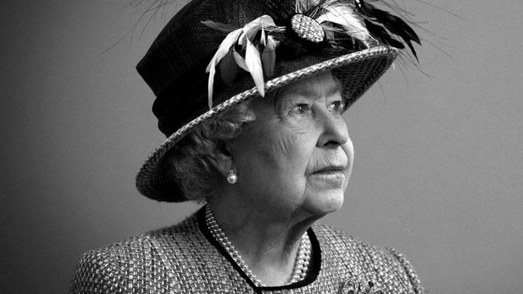 Her majesty the queen looking up at the  top right of a box
