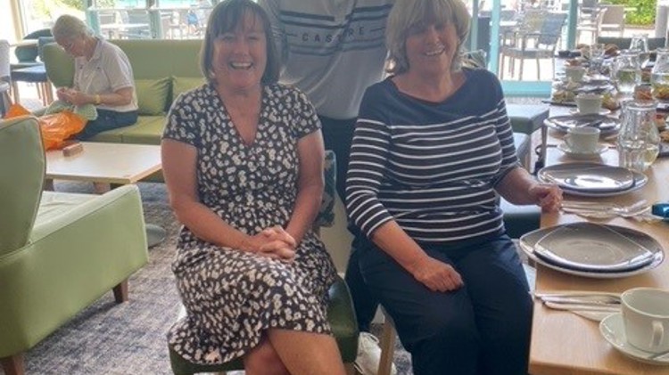 Two women and a man posing for a smiling picture.