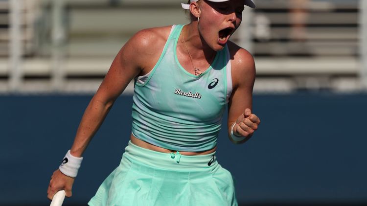 Female tennis player holding racket and celebrating