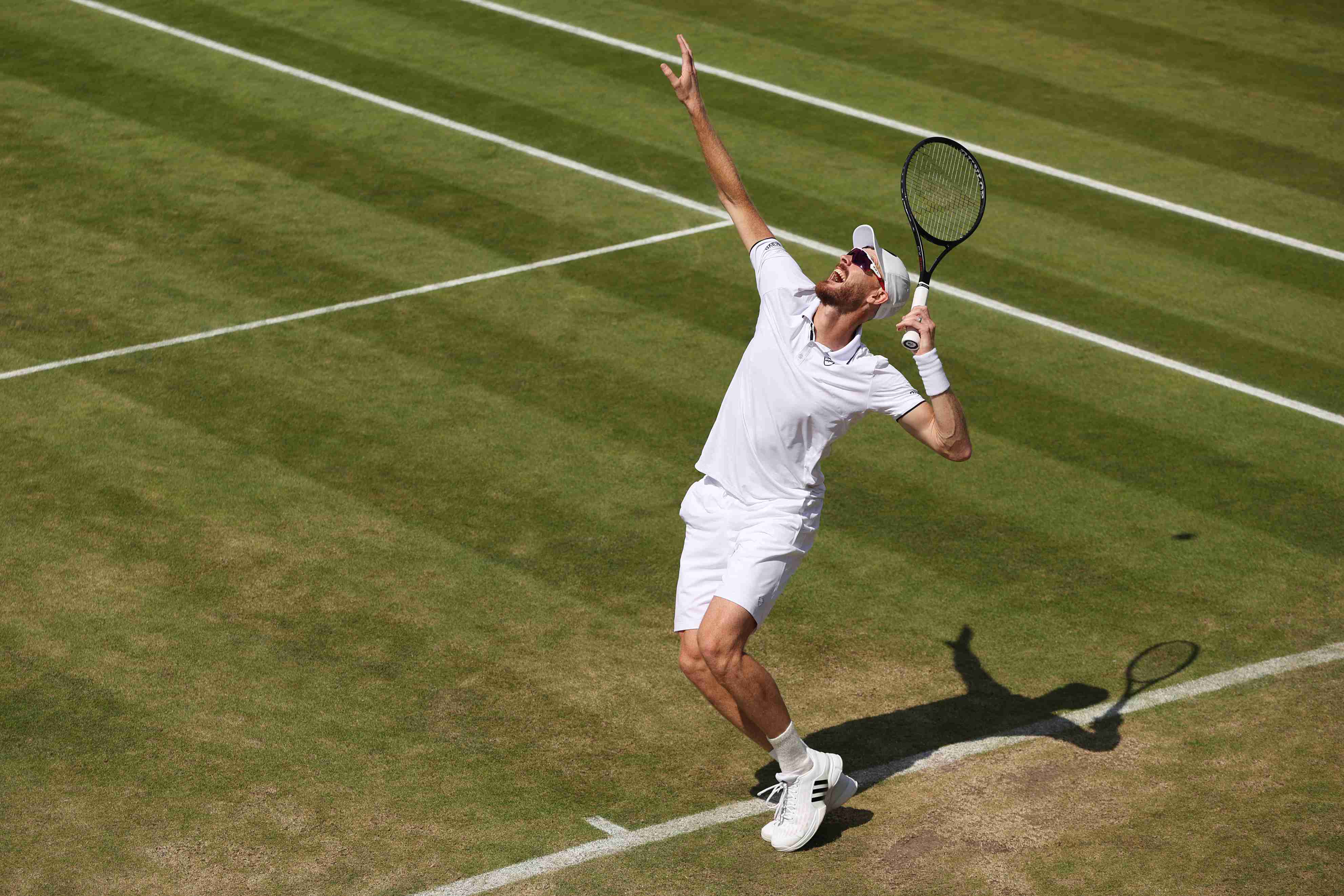 British doubles star Jamie Murray preparing to hit a serve on court at Wimbledon