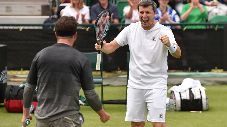 Two male tennis players cheering each other