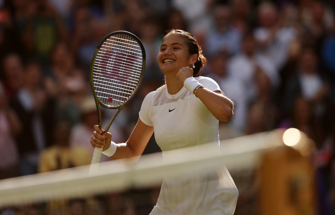 Emma Raducanu smiles in celebration after winning the opening round at Wimbledon 2022