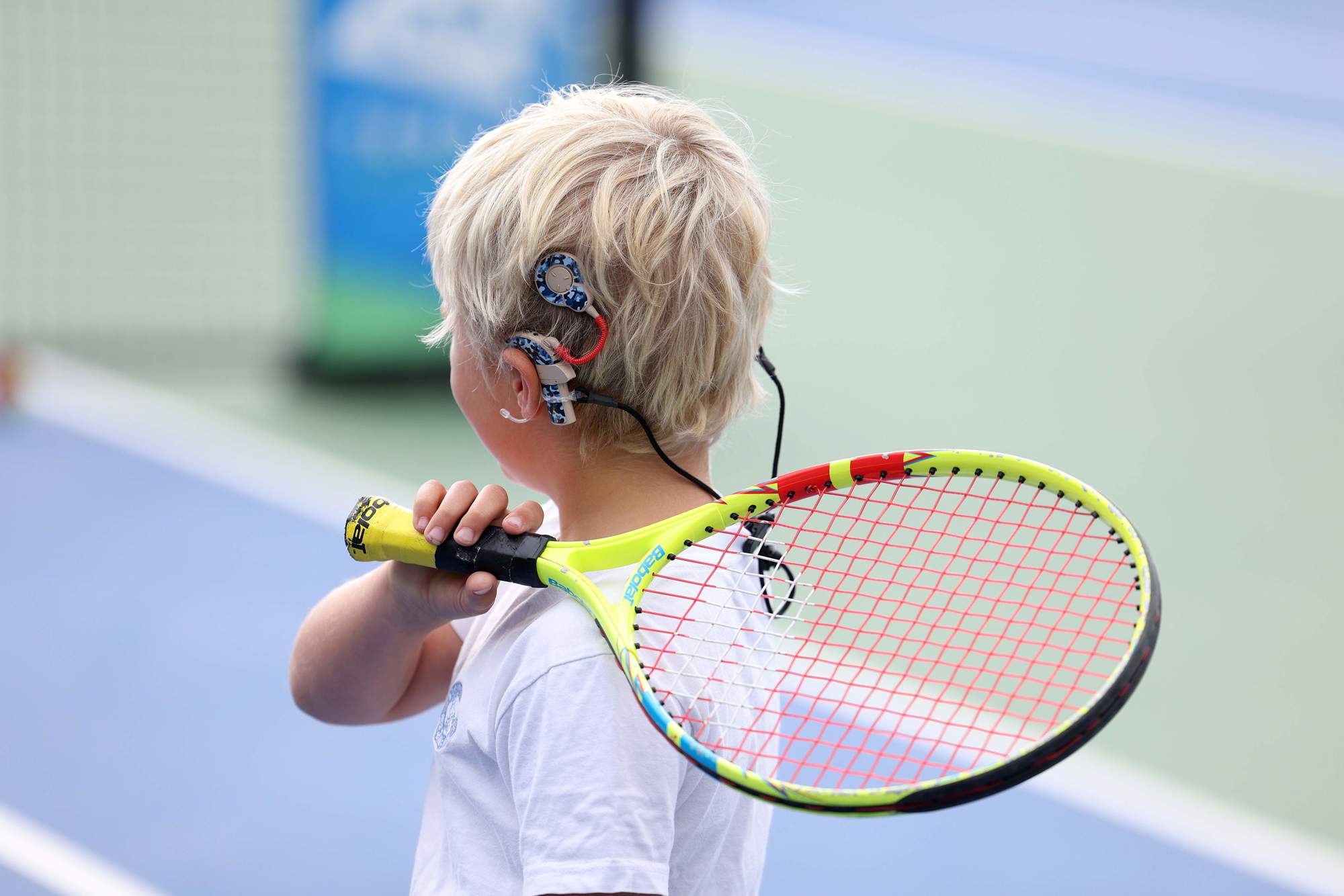A young boy wearing a hearing aid during the youth session at the Deaf Nationals Festival at the National Tennis Centre