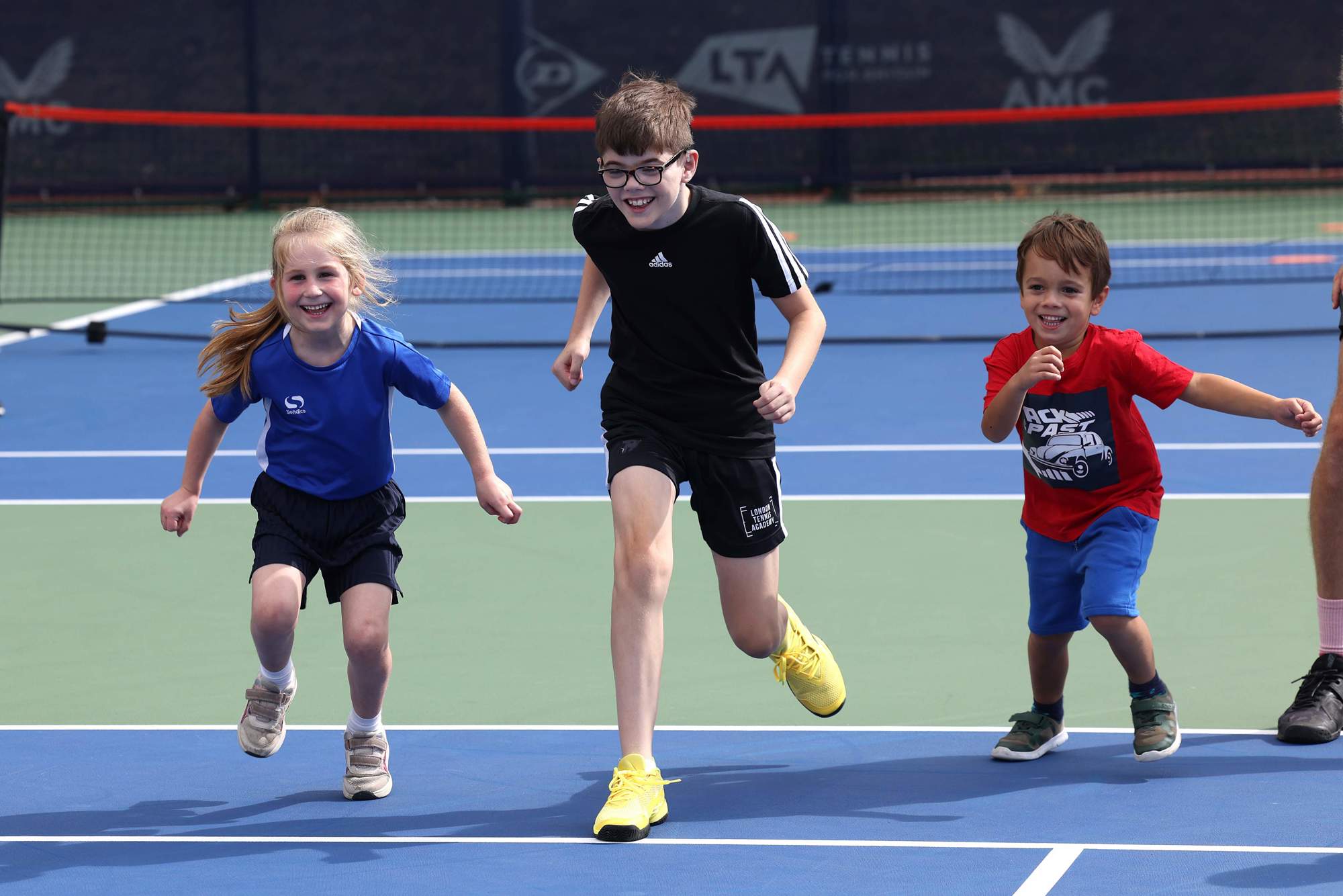Kids who attended the youth session at the Deaf Nationals festival racing on court at the National Tennis Centre