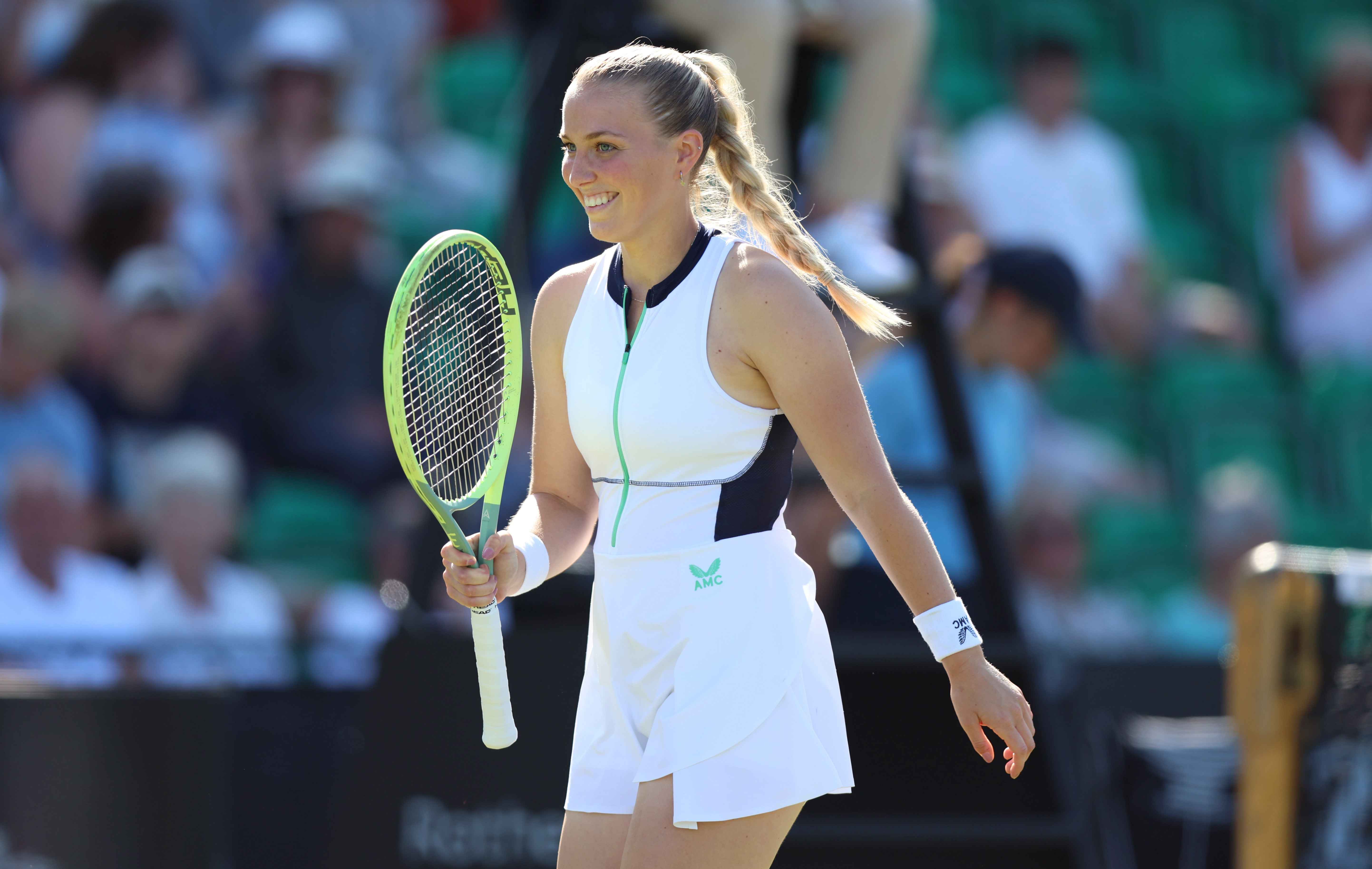 An image of Ali Collins holding her racket up on court