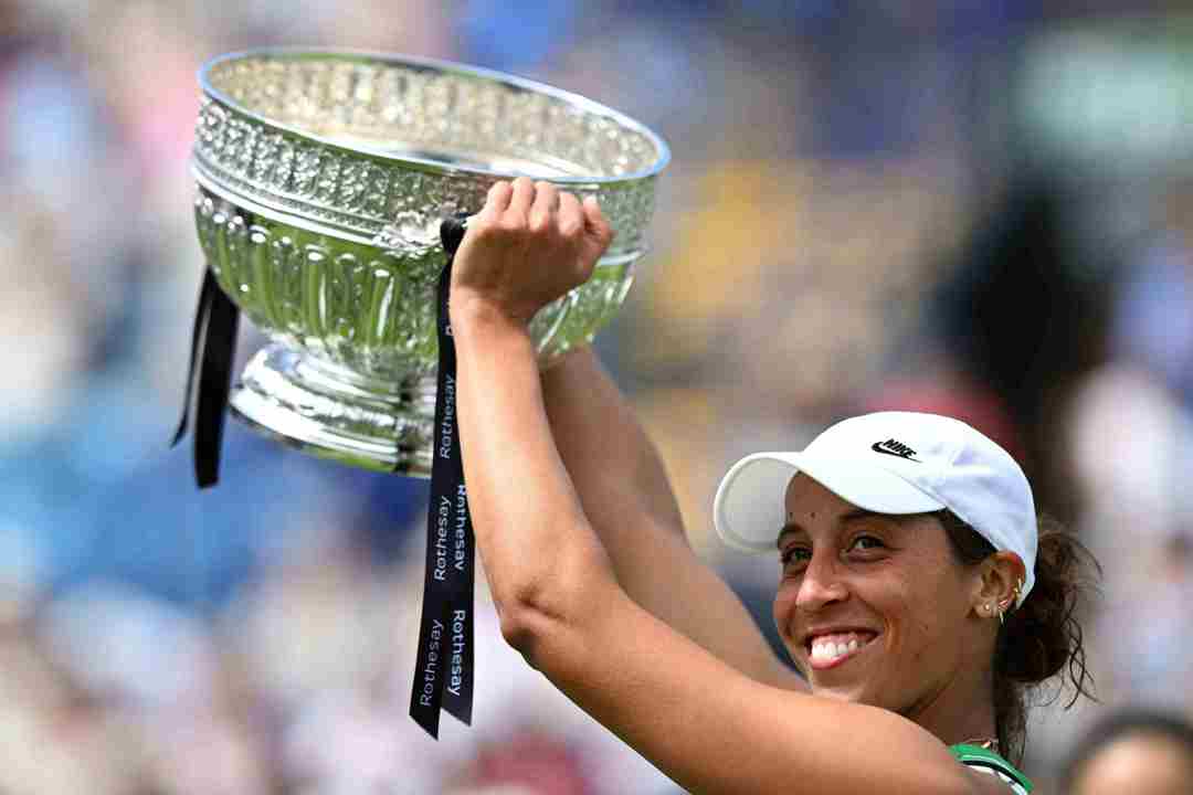 Madison Keys lifting the Eastbourne trophy above her head on court in celebration