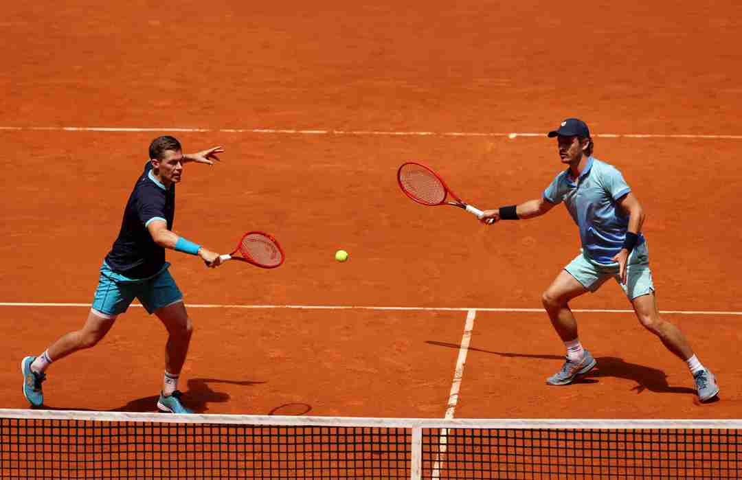 Neal Skupski hitting a backhand slice on court at the Madrid alongside Wesley Koolhof