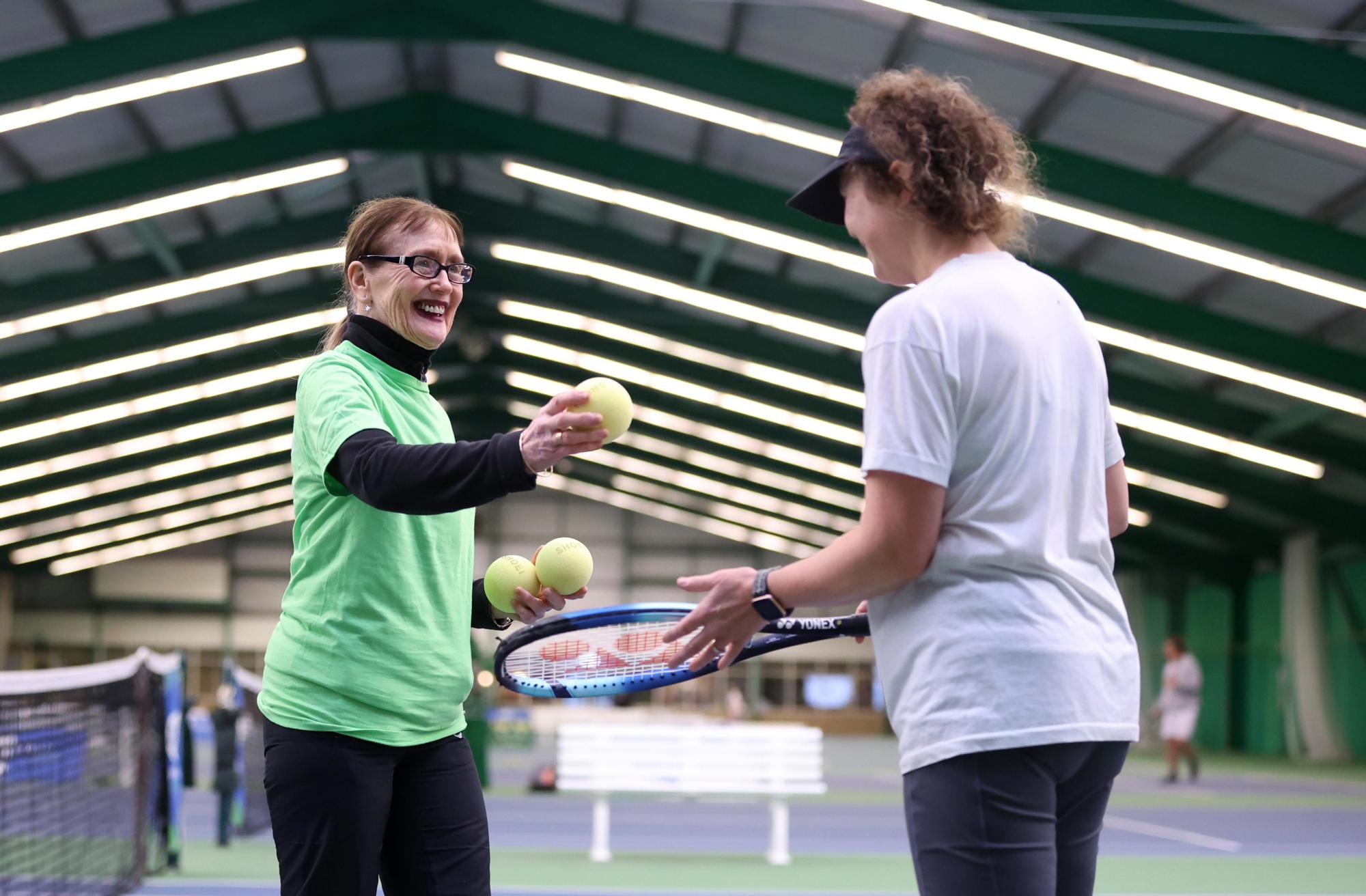 A volunteer interacts with Bethan Jones as she competes during the Visually Impaired Tennis National Finals 2023 