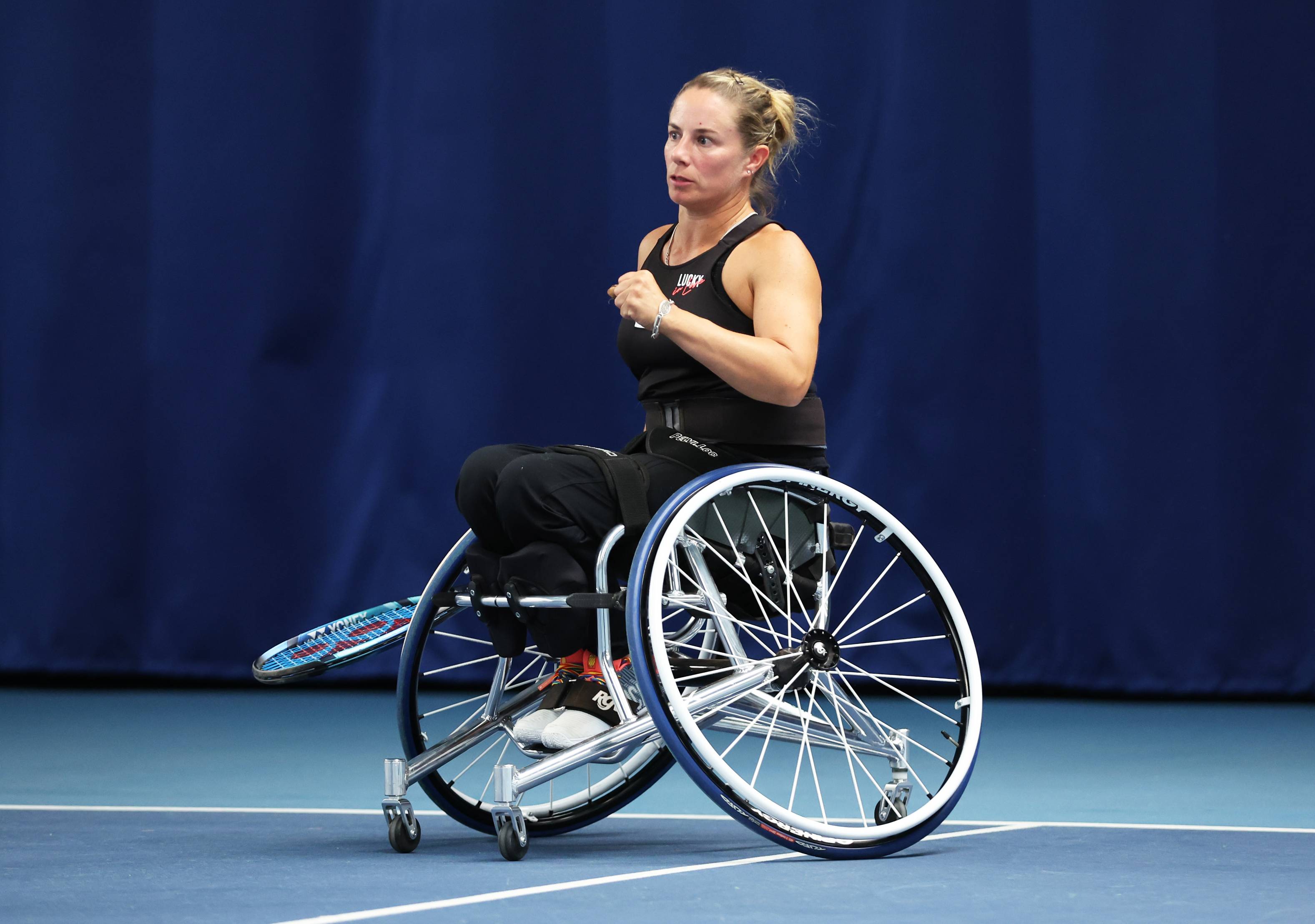 Wheelchair tennis player Lucy Shuker clenching her fist on court while sat in her wheelchair 