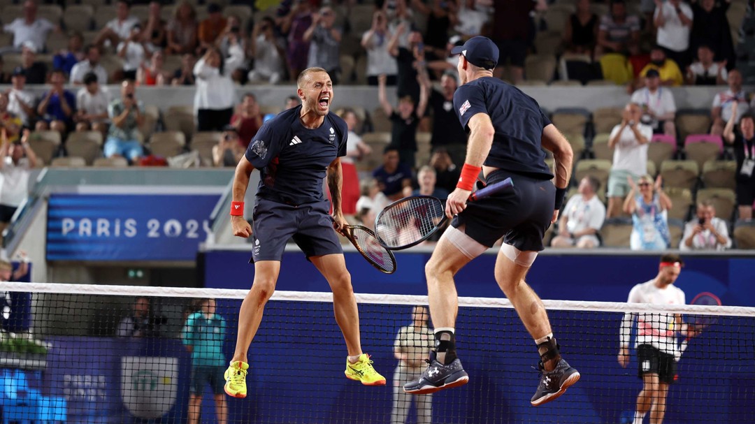 Dan Evans and Andy Murray jumping up and down on court at the Olympics after reaching the quarter-final