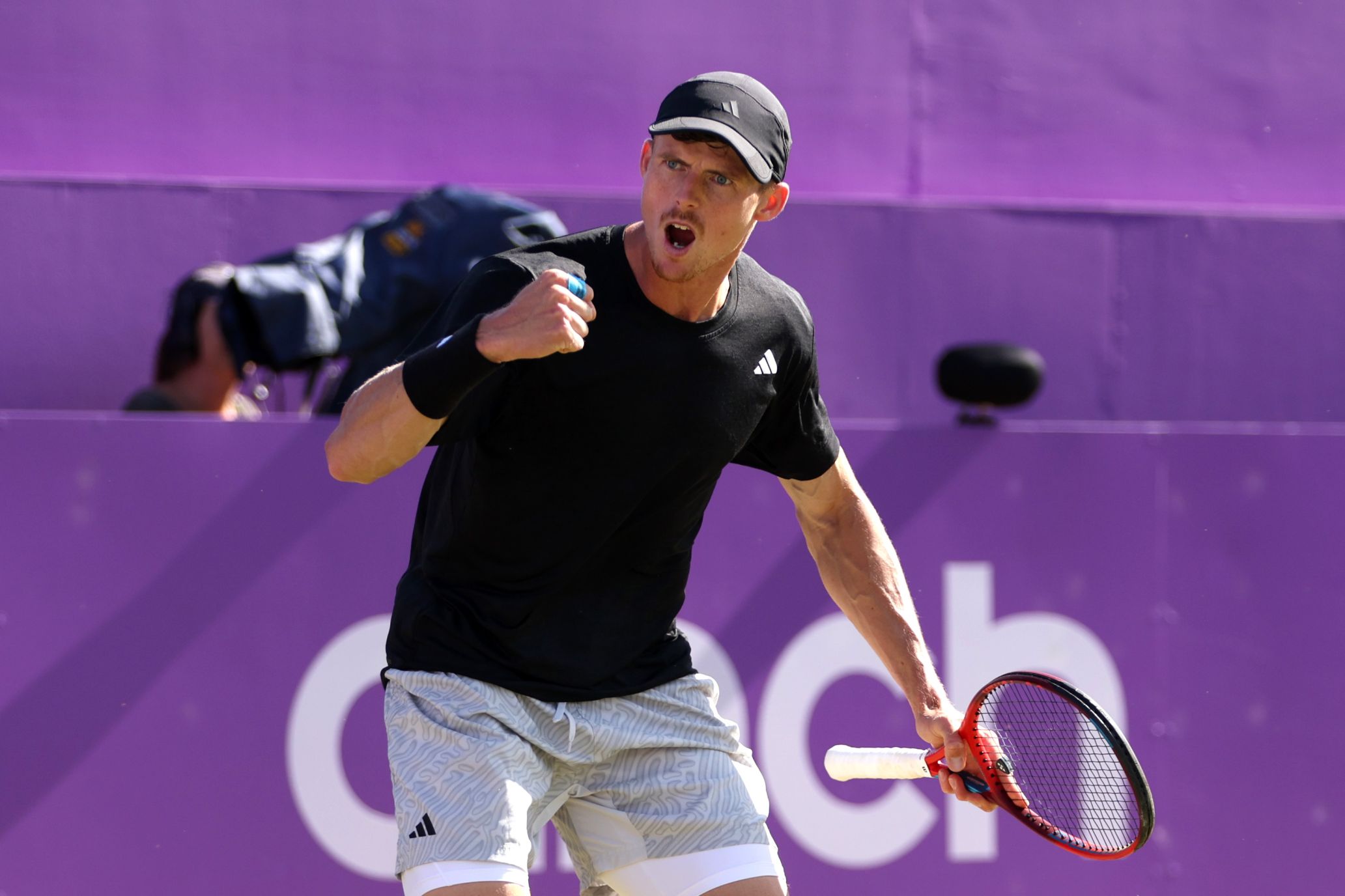 Billy Harris clenching his fist and cheering on court with cinch championships branding behind him