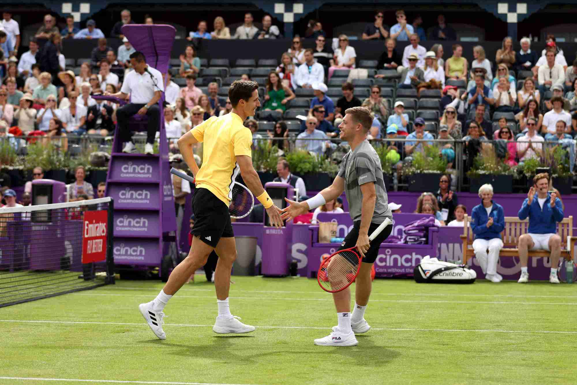 Neal Skupski and Joe Salisbury high-fiving each other on court at the cinch Championships during the fan day exhibition match