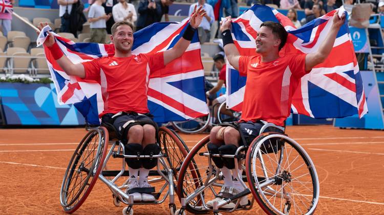 Alfie Hewett and Gordon Reid holding up GB flags behind their head at the Paralympics final