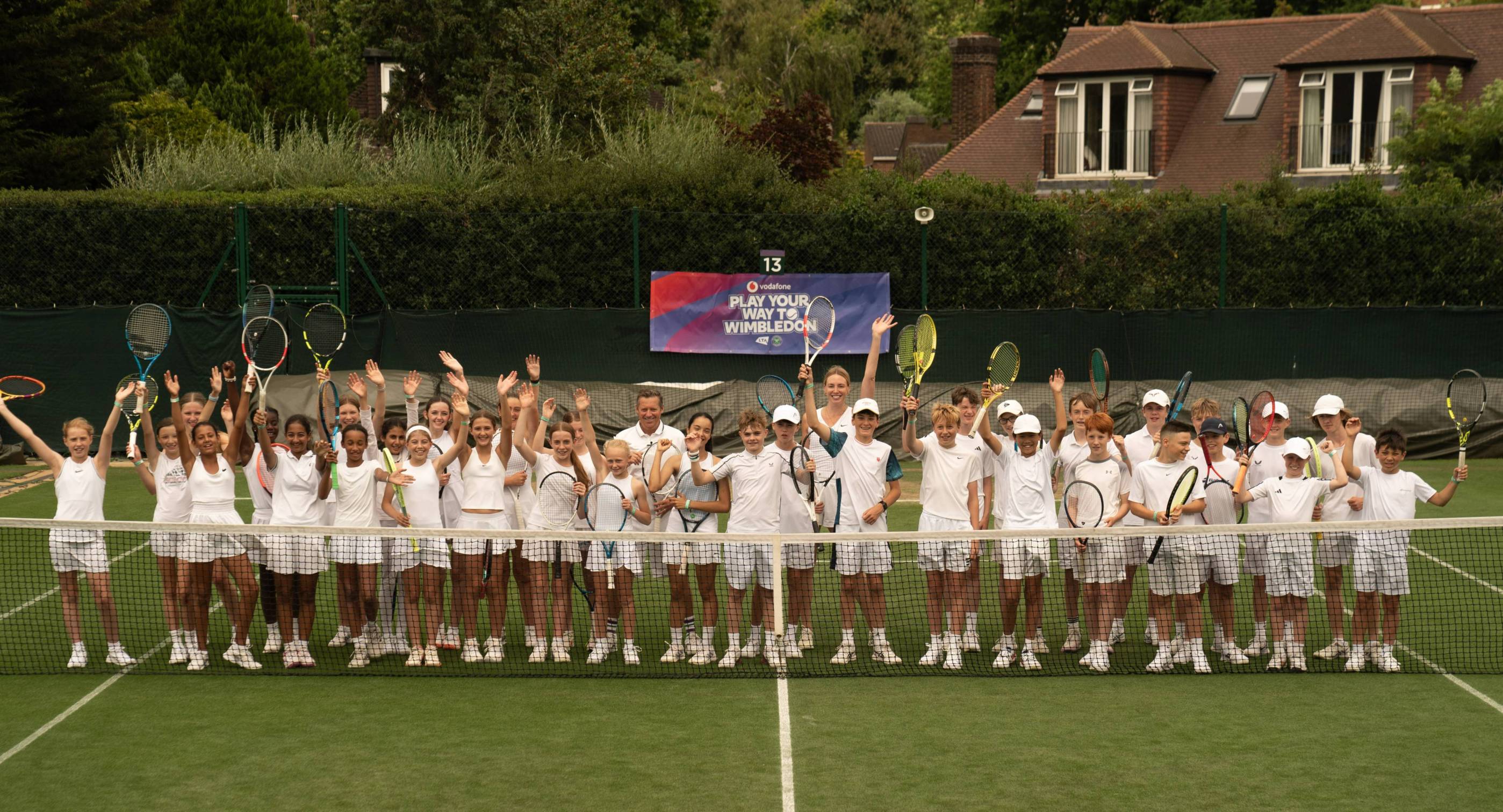 A group of players from the PLay Your Way to Wimbledon competition celebrating on court together