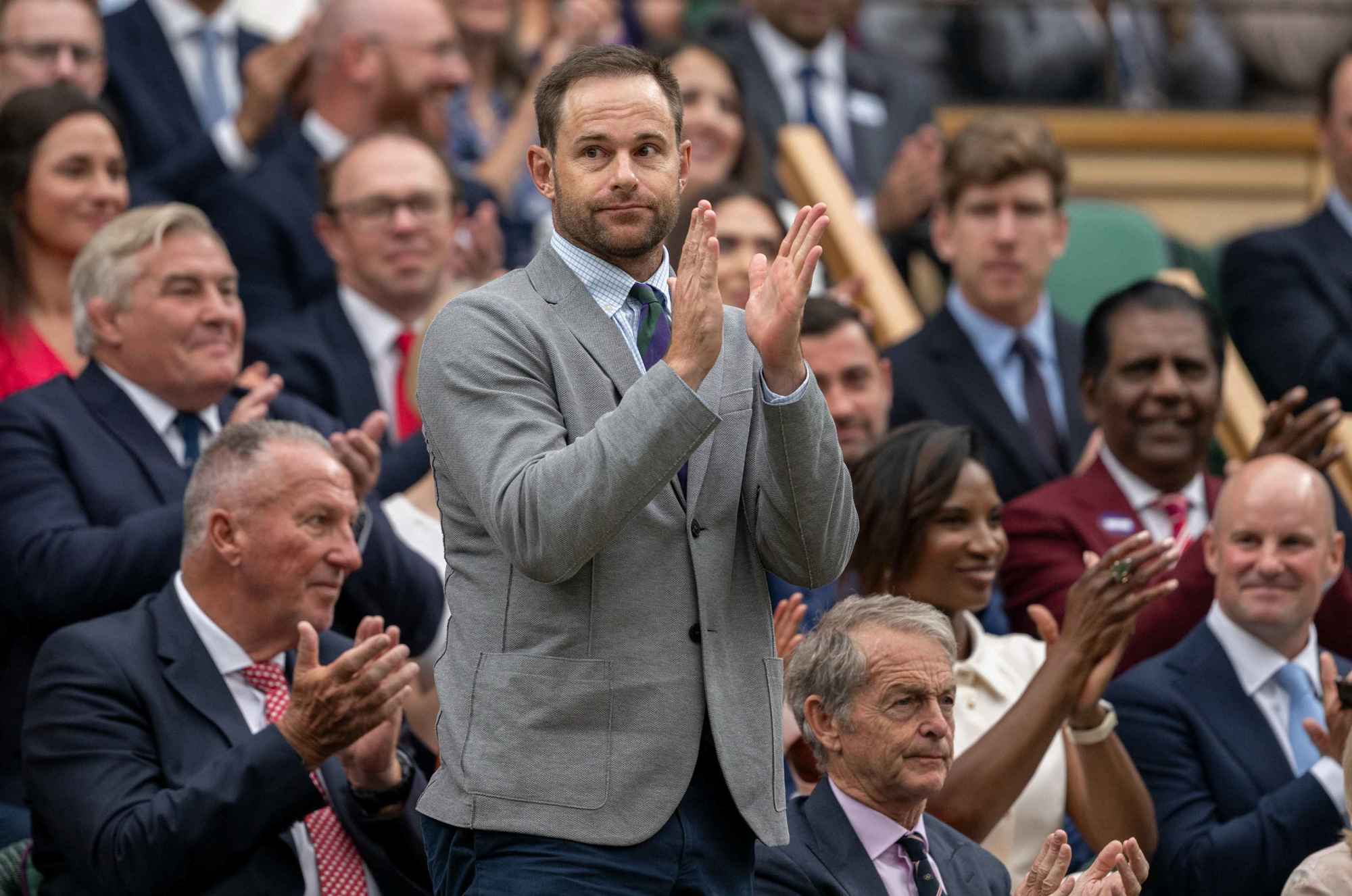 Former Wimbledon runner-up Andy Roddick stands and applauds on Centre Court at Wimbledon