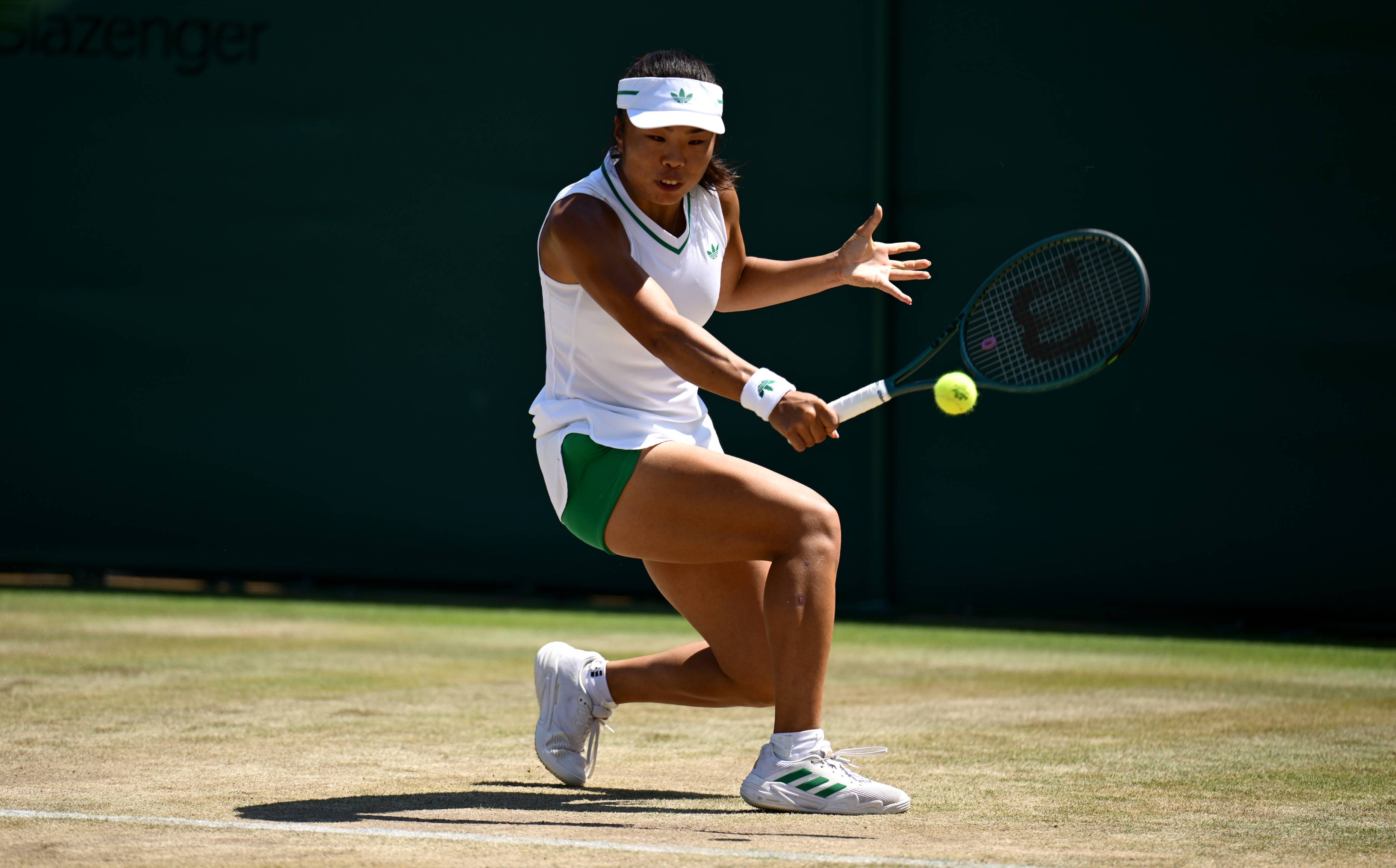 Mimi Xu hitting a backhand on the grass courts at Wimbledon
