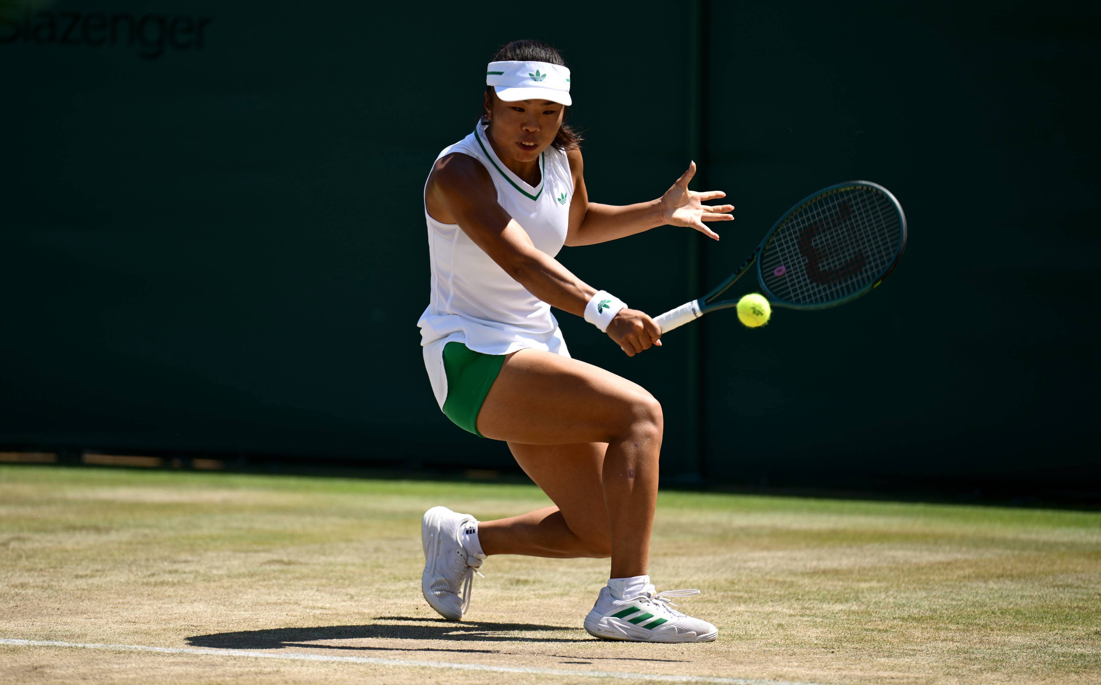 Mimi Xu hitting a backhand on the grass courts at Wimbledon
