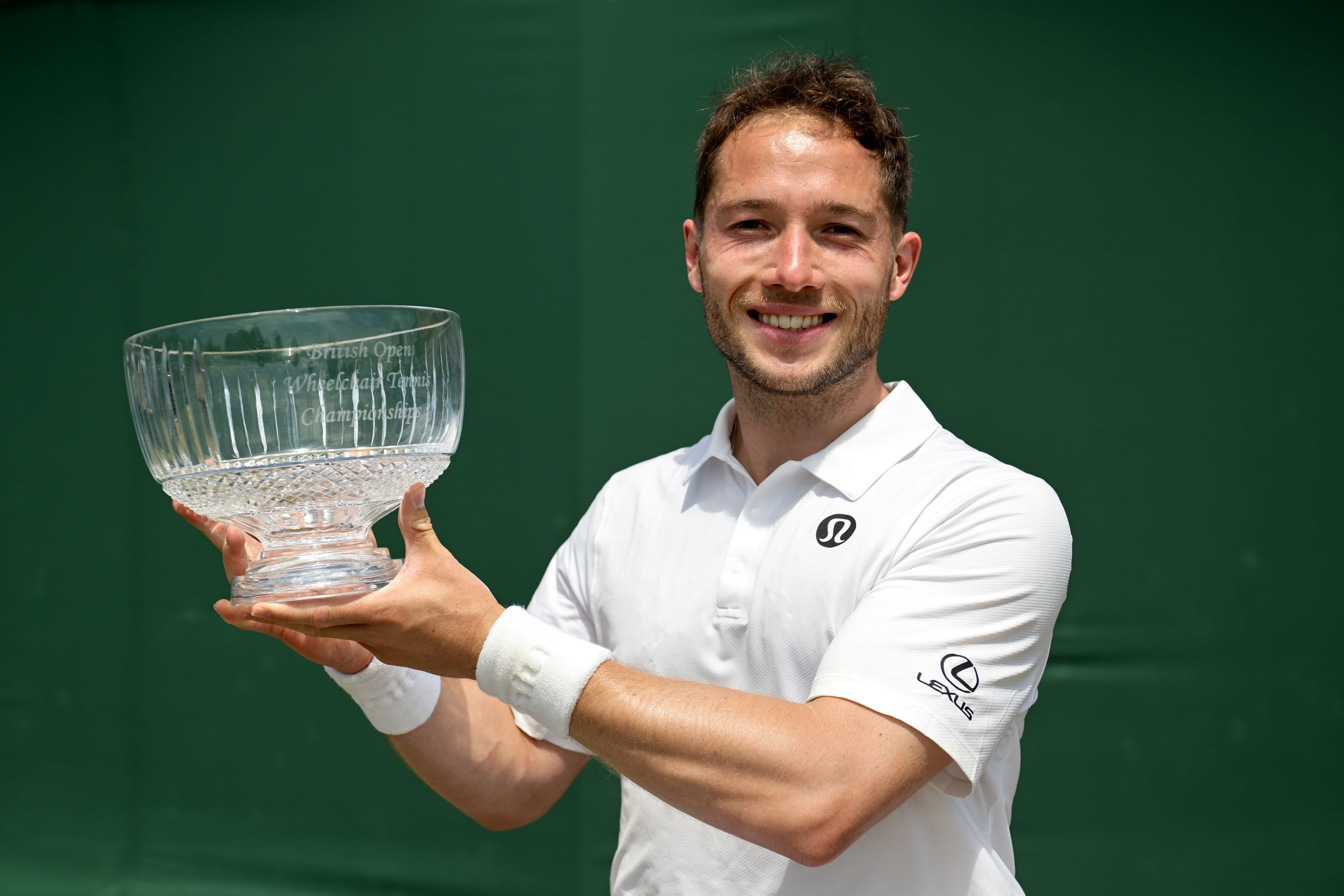 Alfie Hewett smiles while lifting the Lexus British Open trophy
