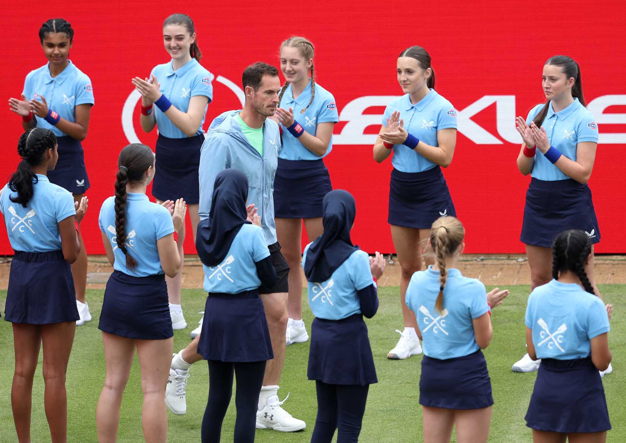 Andy Murray being surrounded and clapped by the ball kids as he walks onto the Andy Murray Arena at the HSBC Championships