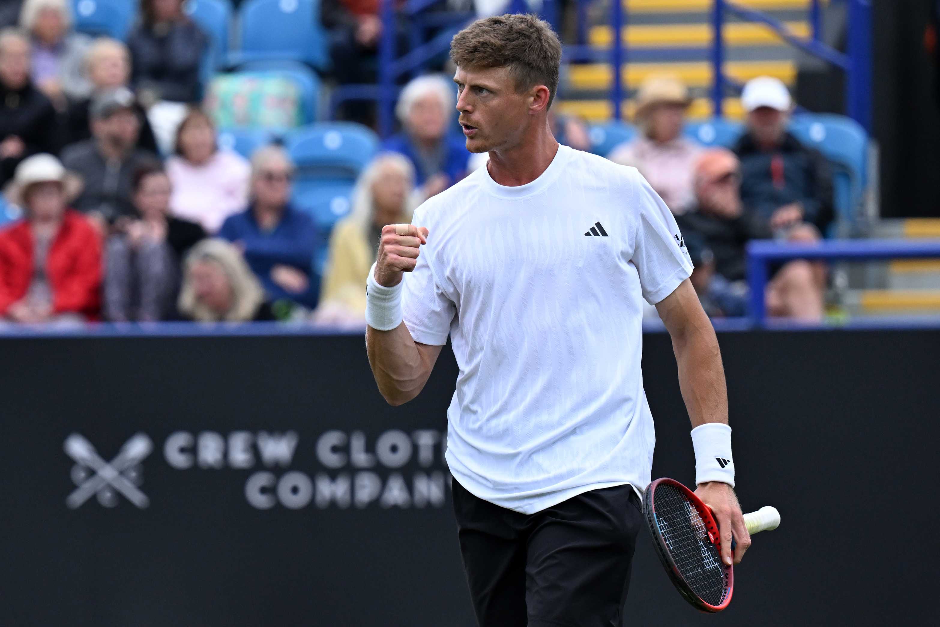 British tennis player Billy Harris clenching his fist and holding his tennis racket on court 