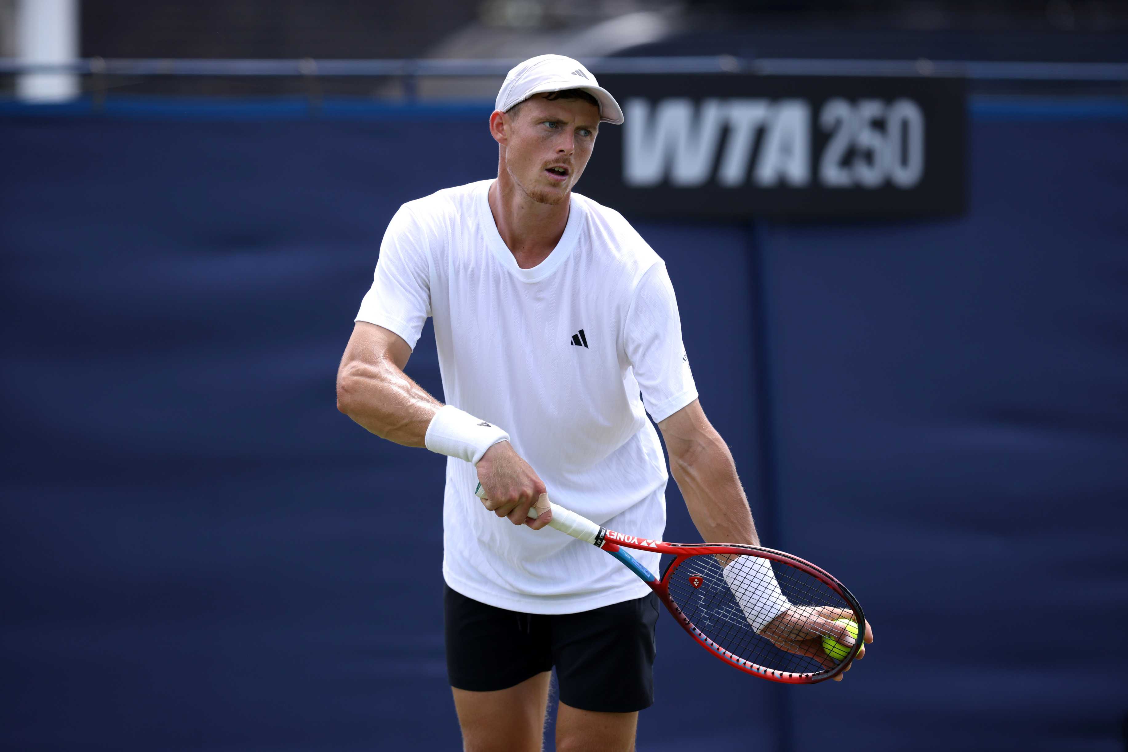 British tennis player Billy Harris preparing to hit a serve on court at the Lexus Eastbourne Open