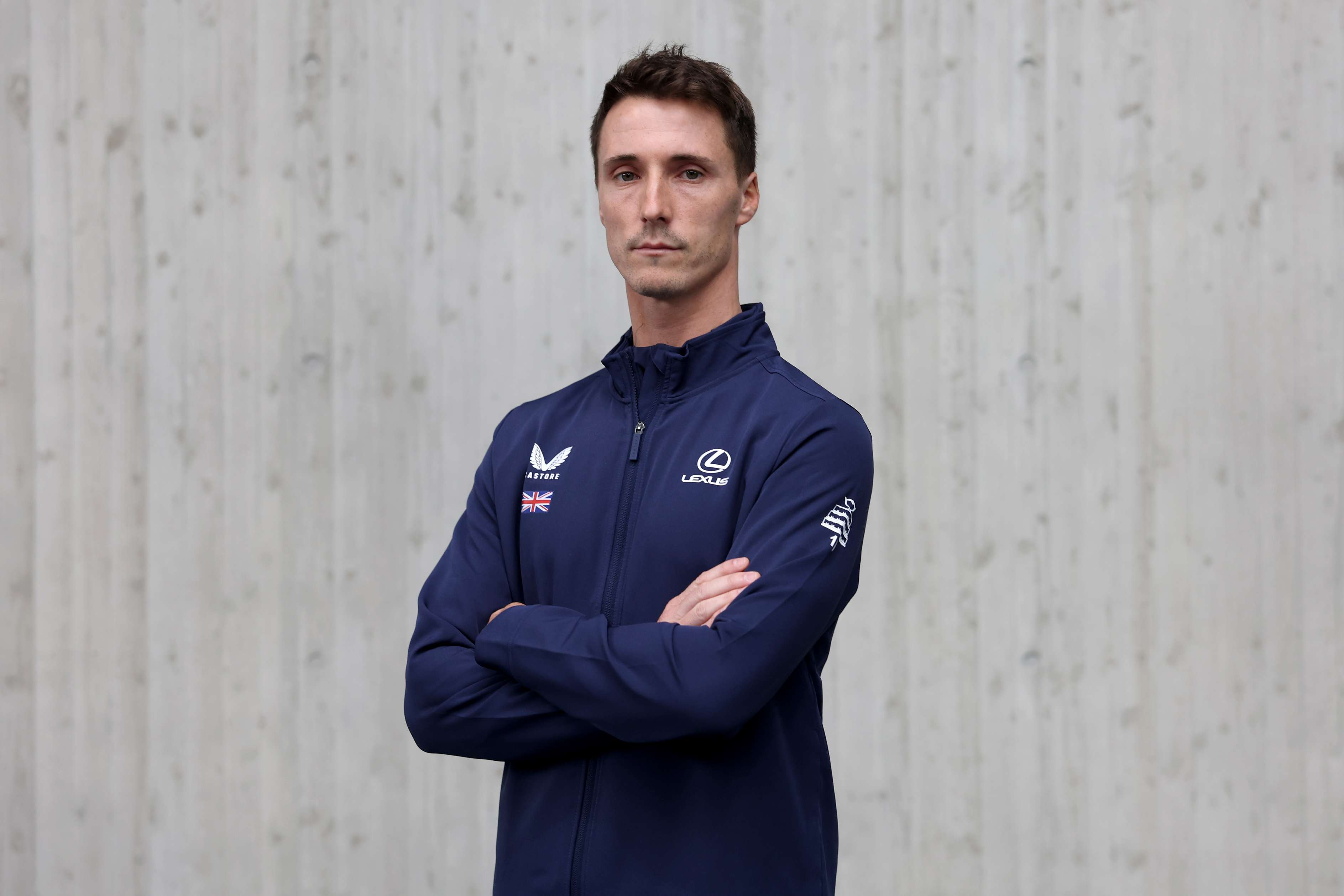British tennis player Joe Salisbury crossing his arms over his chest in his Lexus GB Davis Cup team kit