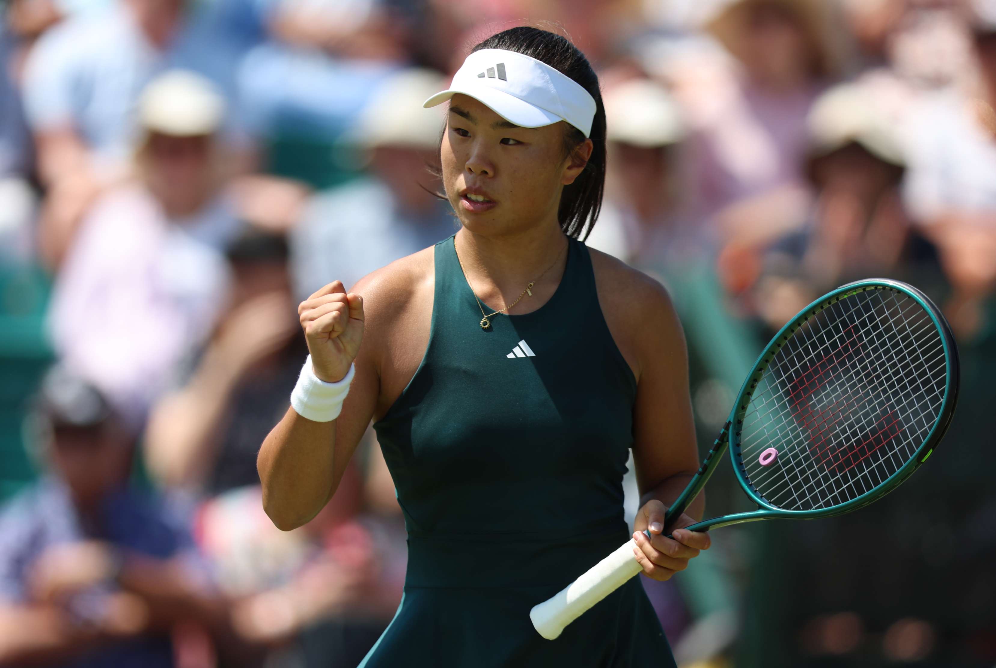 British tennis player, Mimi Xu clenching her fist on court at the Lexus Nottingham Open while holding her tennis racket in her other hand 